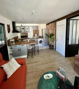eine Küche und ein Wohnzimmer mit einem Sofa und einem Tisch in der Unterkunft Appartement de charme - Cholet Centre in Cholet