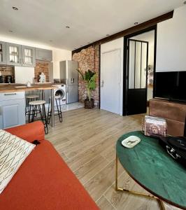 ein Wohnzimmer mit einem Sofa und einer Küche in der Unterkunft Appartement de charme - Cholet Centre in Cholet