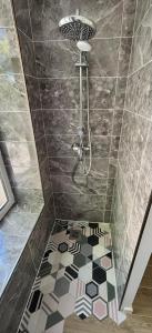 ein Bad mit einer Dusche und Fliesenboden in der Unterkunft Appartement de charme - Cholet Centre in Cholet