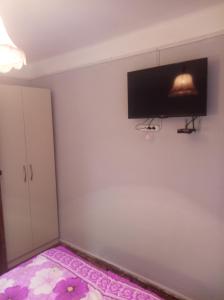 a bedroom with a flat screen tv on the wall at Tsovella House in Jermuk