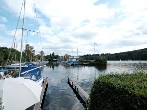 Entspanntes Wohnen in der Nähe des Baldeneysee في إيسن: مجموعة من القوارب مرساة على رصيف في الماء