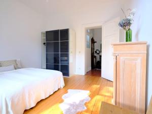 1 dormitorio con cama blanca y suelo de madera en Entspanntes Wohnen in der Nähe des Baldeneysee, en Essen