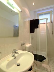 a bathroom with a sink and a toilet and a mirror at Entspanntes Wohnen in der Nähe des Baldeneysee in Essen