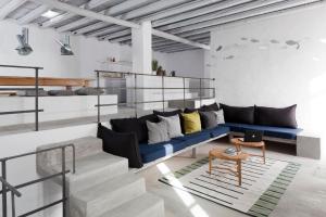 a living room with a blue couch and a table at Coco-Mat Eco Residences Serifos in Vayiá
