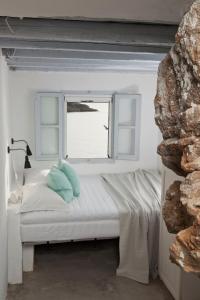 a room with a window and a bed with a pillow at Coco-Mat Eco Residences Serifos in Vayiá