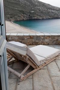 a chaise lounging chair on a patio near the water at Coco-Mat Eco Residences Serifos in Vayiá