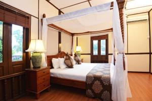1 dormitorio con cama con dosel en una habitación en LaVilla By Holiday Villa Cherating, en Cherating