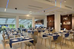 un ristorante con tavoli e sedie blu e finestre di Hotel Romagna a Cattolica