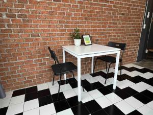 a white table and two chairs and a brick wall at 3l9B Chiangmai Gate Best location 3 bedrooms apartment in Chiang Mai