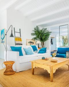 sala de estar con sofá blanco y mesa de centro de madera en Belle villa rétaise 4 étoiles avec piscine chauffée, en La Couarde-sur-Mer