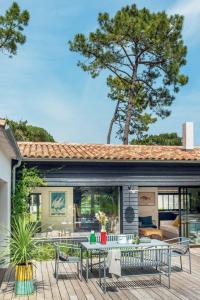 un patio con mesa y sillas en una terraza en Belle villa rétaise 4 étoiles avec piscine chauffée, en La Couarde-sur-Mer