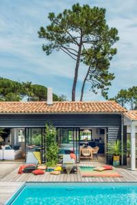 un patio al aire libre con piscina y una casa en Belle villa rétaise 4 étoiles avec piscine chauffée, en La Couarde-sur-Mer