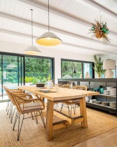 comedor con mesa de madera y sillas en Belle villa rétaise 4 étoiles avec piscine chauffée, en La Couarde-sur-Mer