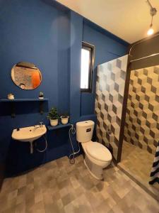 a blue bathroom with a toilet and a sink at 3l9B Chiangmai Gate Best location 3 bedrooms apartment in Chiang Mai