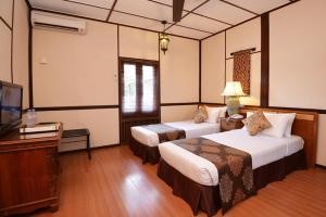 a hotel room with two beds and a television at ViVilla by Holiday Villa Cherating in Cherating +7 photos