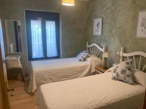a bedroom with two beds and a window at Casa del Plantel in La Granja de San Ildefonso
