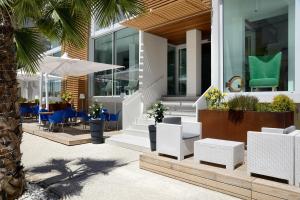 een huis met stoelen en tafels en een palmboom bij Hotel Romagna in Cattolica