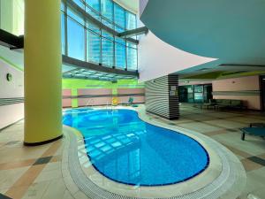 a large blue swimming pool in a building at HiGuests - Modern Apt in Dubai Marina With Pool and Gym in Dubai