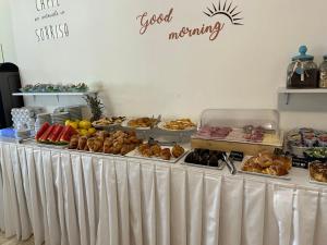 ein Buffet mit verschiedenen Backwaren und Speisen darauf in der Unterkunft Hotel Fedora Rimini in Rimini