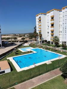 an image of a swimming pool in front of apartment buildings at Flamenco playa in El Puerto de Santa María