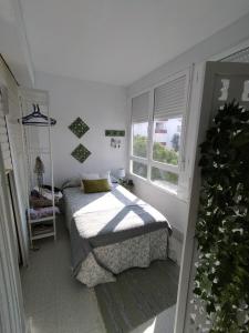 a small bedroom with a bed and a window at Flamenco playa in El Puerto de Santa María