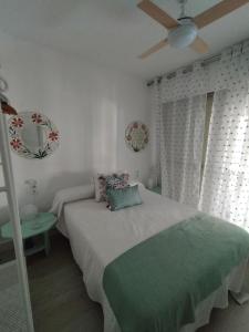 a bedroom with a bed and a ceiling fan at Flamenco playa in El Puerto de Santa María