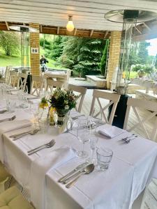 una mesa con mantel blanco y cubiertos en Noce i Dnie Hotel, en Konstancin-Jeziorna
