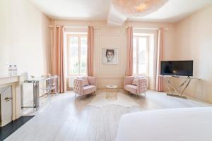 a bedroom with a bed and two chairs and a tv at La Villa Ribière in Auxerre