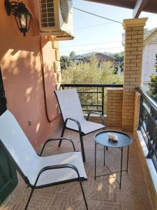 Mirmidones Corfu Apartment في Petrití: كرسيين وطاولة على شرفة