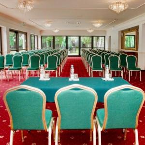 een vergaderzaal met een groene tafel en stoelen bij Noce i Dnie Hotel in Konstancin-Jeziorna