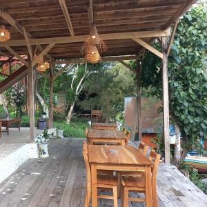 a wooden table and chairs on a wooden deck at Scuba Republic Beach Bungalows in Bira