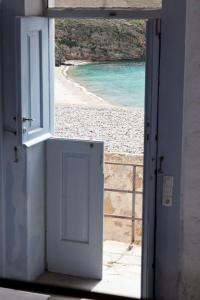 an open door with a view of a beach at Coco-Mat Eco Residences Serifos in Vayiá