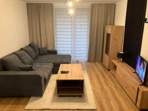 a living room with a couch and a tv at Apartmán Nelka v Poprade in Poprad