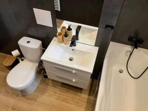 La salle de bains est pourvue de toilettes blanches et d'un lavabo. dans l'établissement Apartmán Nelka v Poprade, à Poprad