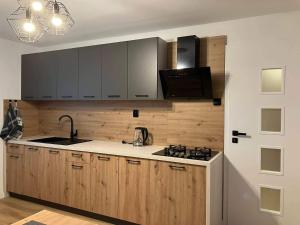 a kitchen with wooden cabinets and a sink and a stove at Apartmán Nelka v Poprade in Poprad