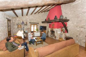 un grupo de personas sentadas en una sala de estar con chimenea en Turismo Rural Can Massot, en Darnius