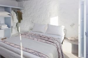a white bedroom with a bed with white walls at Coco-Mat Eco Residences Serifos in Vayiá