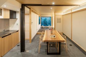 a kitchen and dining room with a table and chairs at Hanatoki Machiya House in Giommachi