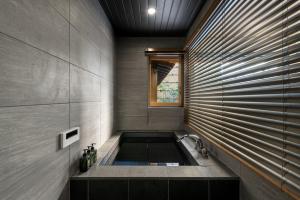 a bathroom with a bath tub with a window at Hanatoki Machiya House in Kyoto +49 photos