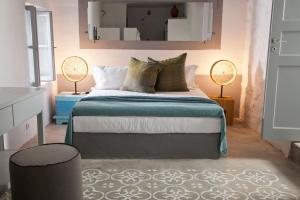 a bedroom with a large bed with two lamps at Coco-Mat Eco Residences Serifos in Vayiá