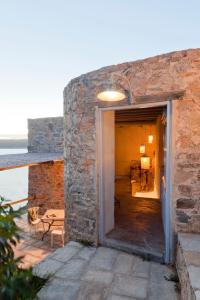 a doorway into a stone building with a view of the ocean at Coco-Mat Eco Residences Serifos in Vayiá