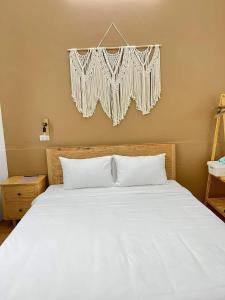 a bedroom with a white bed with a curtain above it at Hidden Hue Homestay in Hue