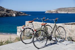 two bikes are parked next to the beach at Coco-Mat Eco Residences Serifos in Vayiá