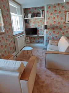 a living room with a couch and a tv at Superbe appartement, face à la vieille ville ! in Boulogne-sur-Mer