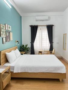 a bedroom with a large bed with blue walls at Hidden Hue Homestay in Hue
