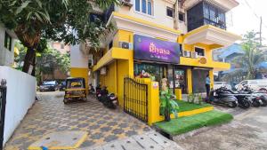 a yellow building with a bike shop on a street at RK 2 and 3 bedroom penthouse in Panaji