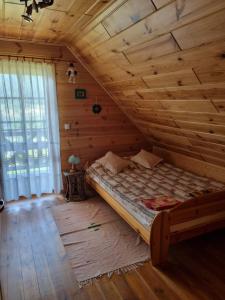 Cama en habitación con techo de madera en Dom letniskowy Uście Gorlickie en Uście Gorlickie