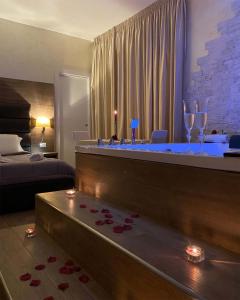 Habitación con bañera con copas de vino y cama en BlueBay Residence Resort, en Taranto