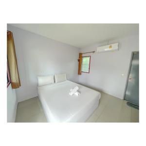 Habitación pequeña con cama blanca y ventana en พักดีรีสอร์ท 2, en Nakhon Ratchasima