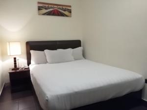 1 cama blanca grande en una habitación de hotel en DM Hotel, en Kota Kinabalu